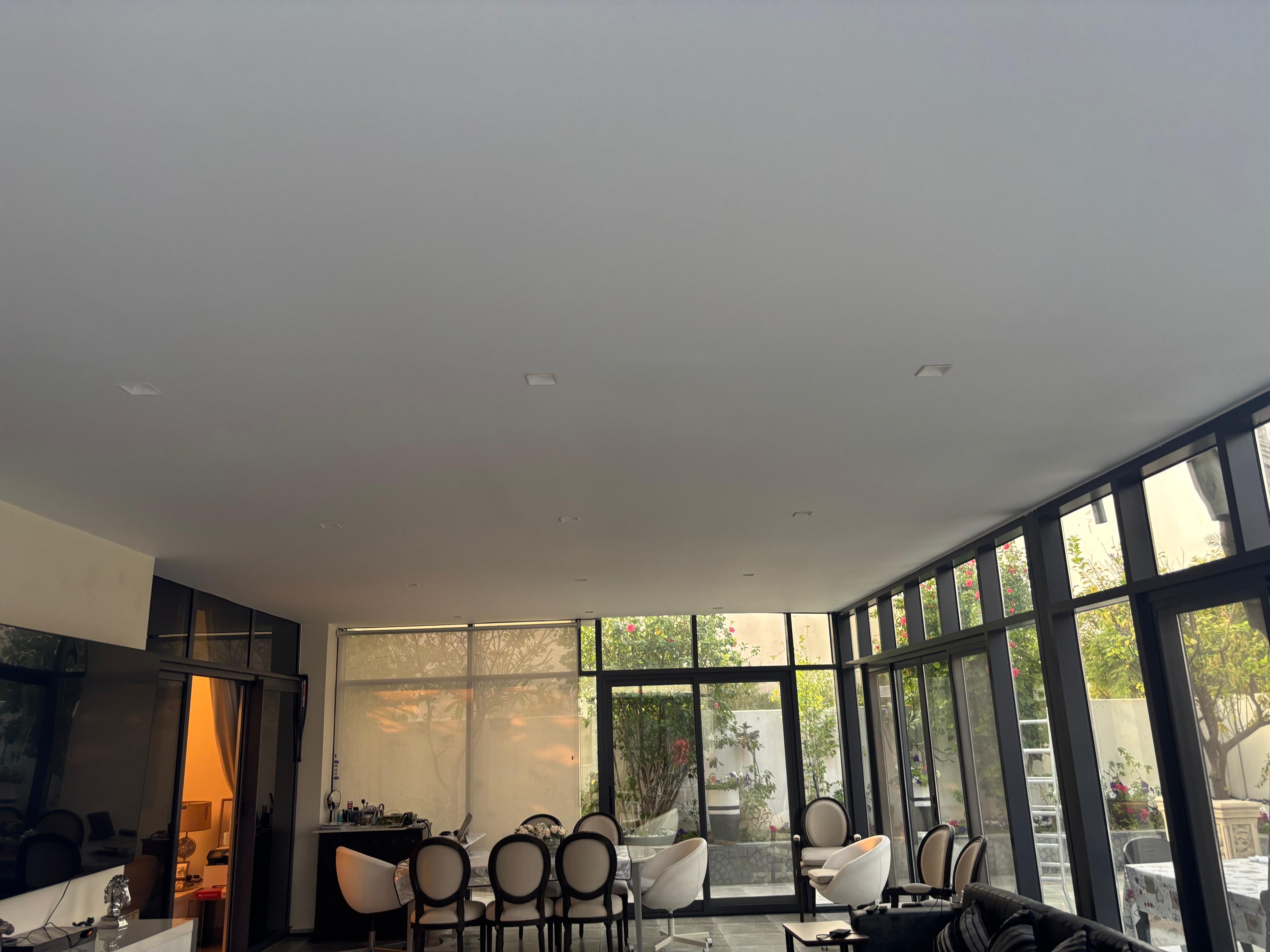 Bright renovated room with floor-to-ceiling glass, dining area, and garden views
